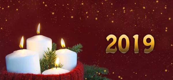 ホワイト クリスマス バーガンディ ベルベット紙と輝く新しい年の背景上のモミの枝と手作りニット赤のウールの帽子の炎の燃焼でアドベントろうそく Web バナー — ストック写真