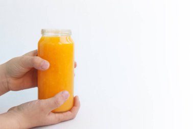 Yaratıcı arka plan beyaz kağıda izole bir çocuğun elinde iki portakal suyu şişe. Kavramı fitness yemek, bitkisel diyet, Bapu, sağlıklı beslenme, kilo kaybetme. Önden görünüm kopya alanı