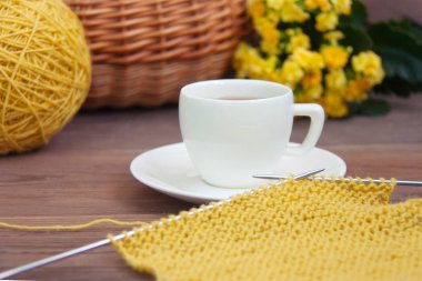 İğneler, beyaz espresso kahve ile sarı yün örgü daire, sepet, ahşap rustik zemin üzerine aranjmani Kupası. Önden görünüm