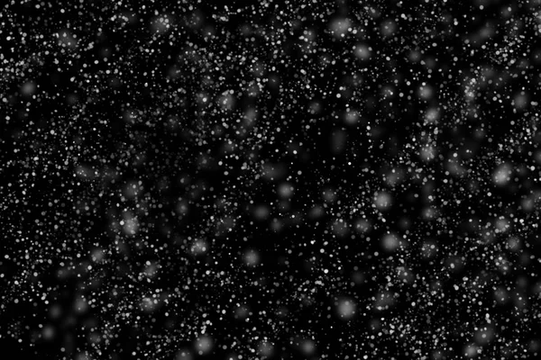 The texture of white snow during a snowfall on a black background