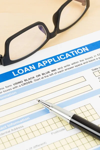 Personal loan application form with glasses, and pen