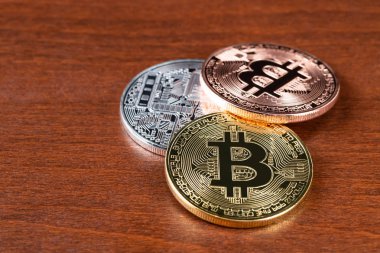 Altın gümüş ve bronz bitcoin belirteci ahşap arka plan üzerinde