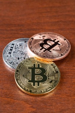 Altın gümüş ve bronz bitcoin belirteci ahşap arka plan üzerinde