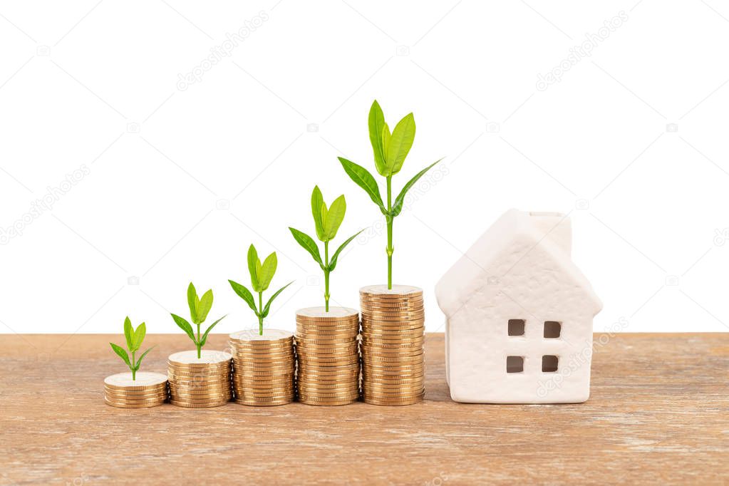 Model house and coin stack with tree on white background mortgage saving concept