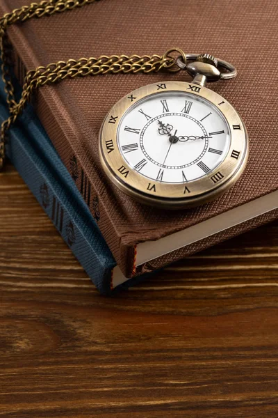 Relógio de bolso vintage com livro sobre fundo de madeira — Fotografia de Stock