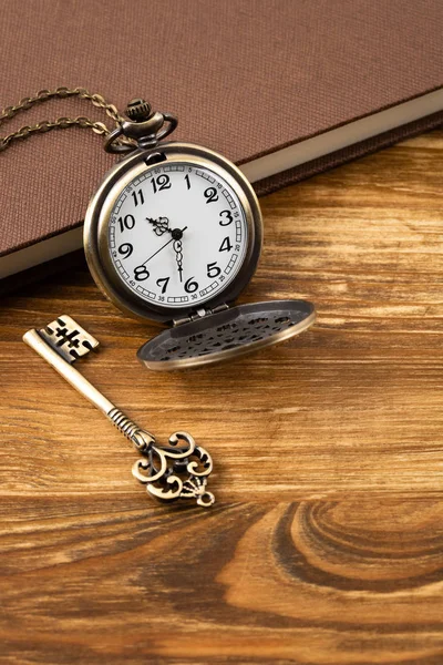 Kaliteli cep saati, anahtar ve ahşap arka taraftaki kitap. — Stok fotoğraf