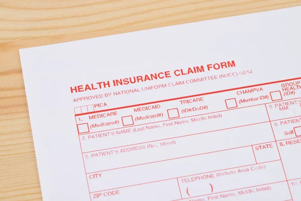 Health insurance claim form on wooden desk — Stock Photo, Image