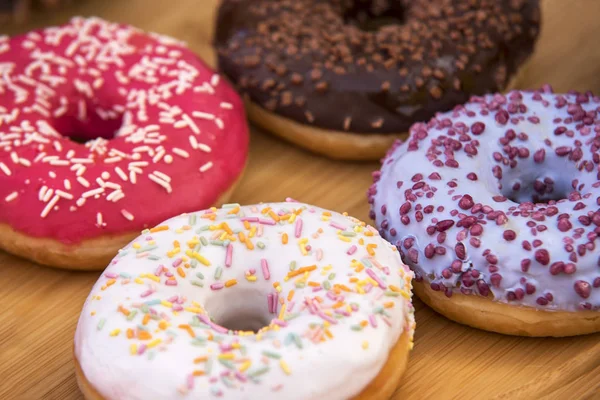 Четыре Пончика Голубой Розовой Белой Шоколадной Глазури Деревянном Подносе — стоковое фото