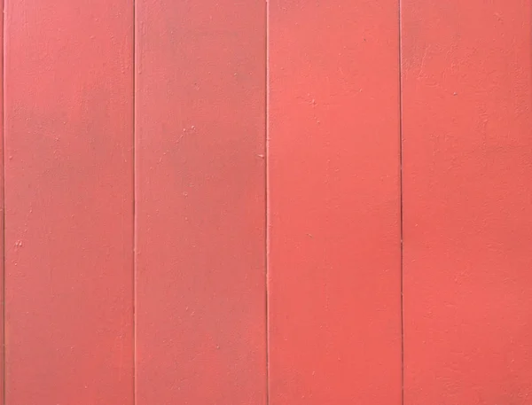 Flat metal surface in a strip, painted with a dark red paint. Weathered and peeling texture. A close-up shot.
