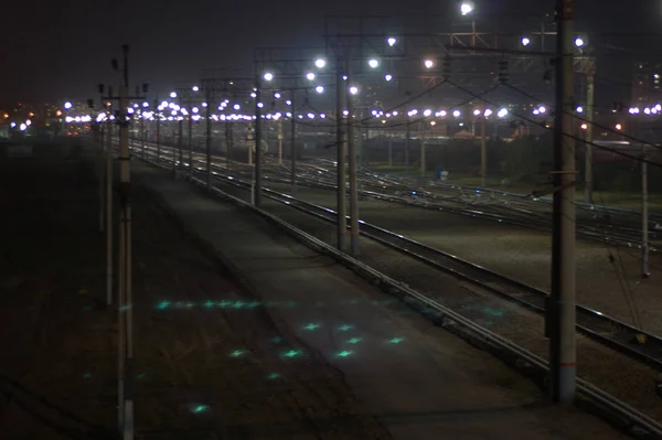 Night shooting of the crossing on the railway tracks, the bridging of the roads at the station flickers in the lights. Blur.