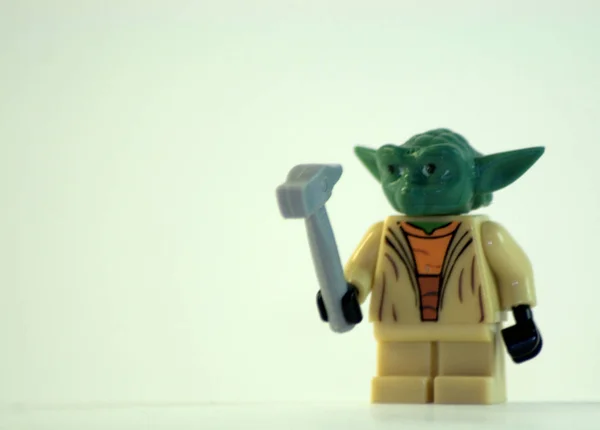 Grand Master Yoda with a hammer in his hand made of plastic. May the force be with you ... The picture was taken in close-up on a white background.