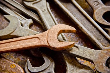 Wrenches top view for construction, industrial, electrician concept design. Old rusty wrench over battered metal table rough style. Labour day background concept. A concept for FathMetal bunch wrenches rusty iron metal tools lying on dark steel table