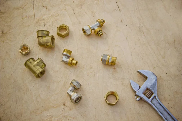 Sıhhi tesisat konsepti. parlak ahşap masa arka plan üzerinde araçları ve borular. Tesisat işleri için montaj ve iki ayarlanabilir anahtarlar. İşçi bayramı arka plan konsepti. Babalar Günü için bir kavram