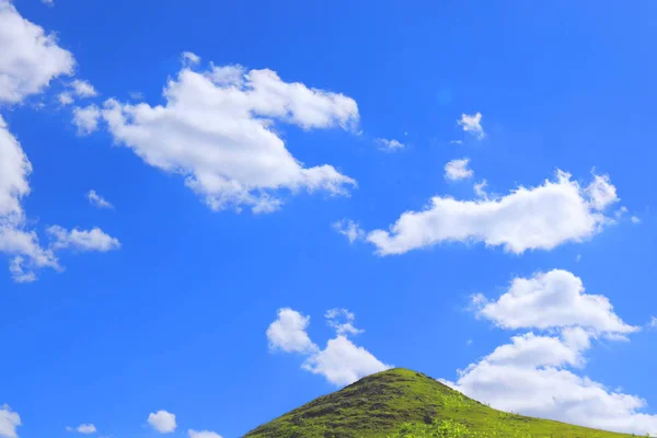 sunny afternoon. wonderful landscape in mountains. grassy rolling hill.Green Hill And Blue Sky With Clouds