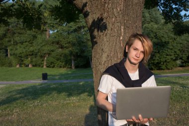 Ofis Binası yakın park çalışan dizüstü bilgisayar ile genç adam