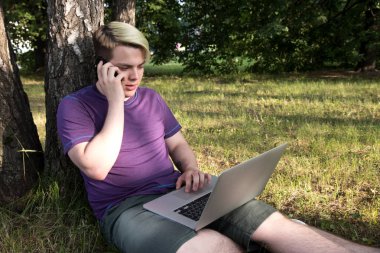 Genç laptop ile adam ve ofis binası yakın park çalışan telefon