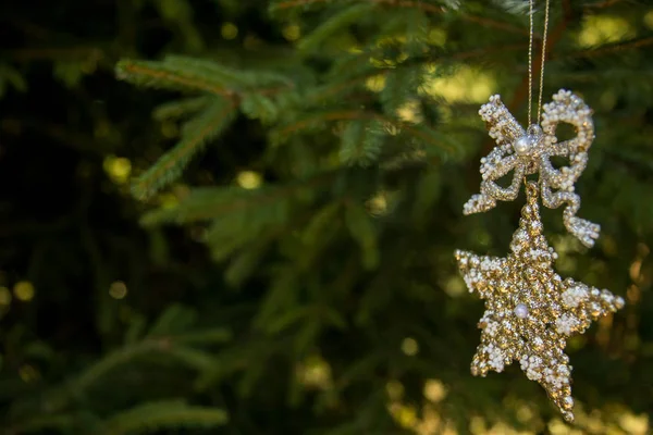 Estrela decorativa dourada em fita em brach borrado de árvore de xmas. Feliz cartão de Natal. Tema de férias de inverno. Feliz Ano Novo . — Fotografia de Stock