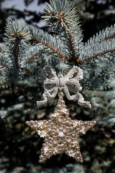 Estrella decorativa dorada en cinta en brach borroso de árbol de Navidad. Feliz tarjeta de Navidad. Tema de vacaciones de invierno. Feliz Año Nuevo . —  Fotos de Stock