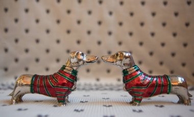 Kırmızı-yeşil Noel kazaklı benekli arka plan üzerinde iki dachshund