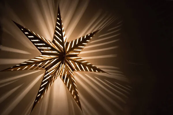 Велика різдвяна золота освітлювальна зірка в темну ніч — стокове фото