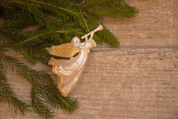 Noel trompet melek oyuncak ahşap arka plan üzerinde Noel ağacı dalı — Stok fotoğraf