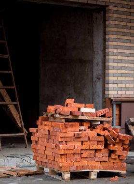 Palet üzerindeki kırmızı tuğla yığını