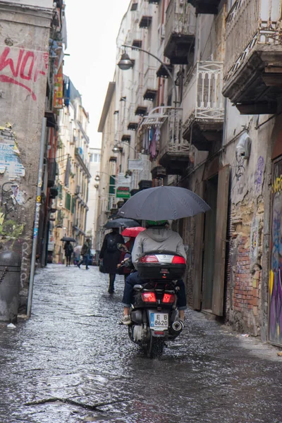 NAPLES, ITALY - 04 November, 2014 8.Young man riding motorbike under umbrella in the rain . — стоковое фото