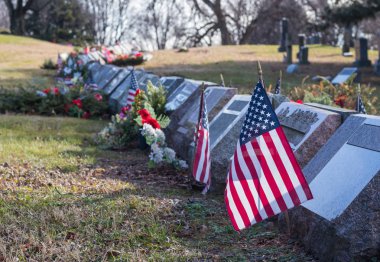 Küçük Amerikan bayrakları ve ulusal mezarlığında mezar taşı.