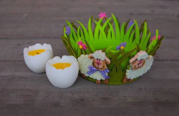 Пасхальный декор с овечками на зеленой корзине и яйцами — стоковое фото