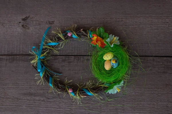 Пасхальное гнездо и венок из яиц на деревянном фоне — стоковое фото