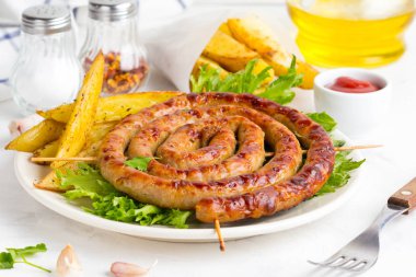 Bitki patates ve ketçap, lezzetli Yaz piknik tabak, sosis şiş üzerinde ızgara sosis bükülmüş hafif bir arka plan üzerinde bir daire içinde