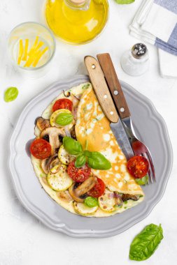 Kızarmış sebze, kabak, domates, soğan, mantar, ince haddelenmiş omlet lezzetli sağlıklı kahvaltı,