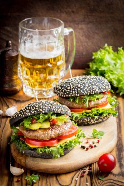 Burger siyah topuz, Dana pirzola, domates, peynir, salata, bira, lezzetli ev yapımı sandviç ile hızlı gıda
