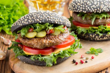 Burger siyah topuz, Dana pirzola, domates, peynir, salata, bira, lezzetli ev yapımı sandviç ile hızlı gıda