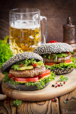 Burger siyah topuz, Dana pirzola, domates, peynir, salata, bira, lezzetli ev yapımı sandviç ile hızlı gıda