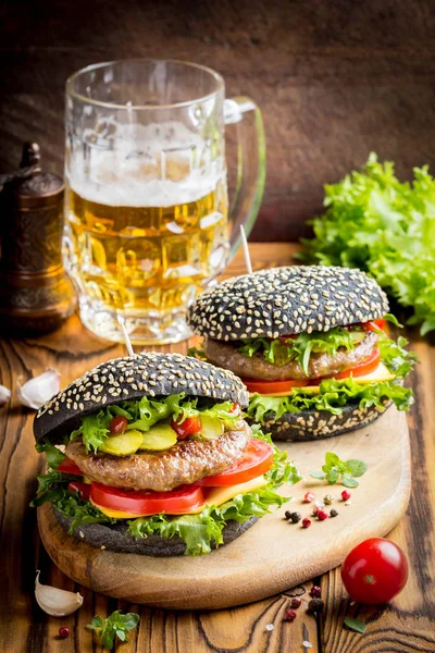 Burger siyah topuz, Dana pirzola, domates, peynir, salata, bira, lezzetli ev yapımı sandviç ile hızlı gıda
