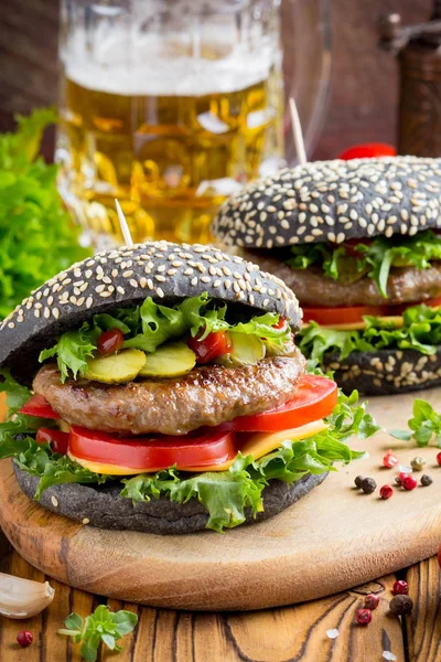Burger siyah topuz, Dana pirzola, domates, peynir, salata, bira, lezzetli ev yapımı sandviç ile hızlı gıda