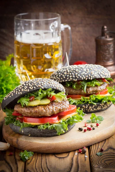 Burger siyah topuz, Dana pirzola, domates, peynir, salata, bira, lezzetli ev yapımı sandviç ile hızlı gıda