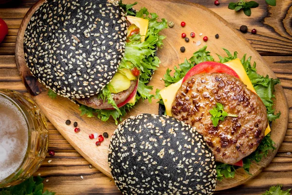 Burger siyah topuz, Dana pirzola, domates, peynir, salata, bira, lezzetli ev yapımı sandviç ile hızlı gıda