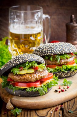 Burger siyah topuz, Dana pirzola, domates, peynir, salata, bira, lezzetli ev yapımı sandviç ile hızlı gıda