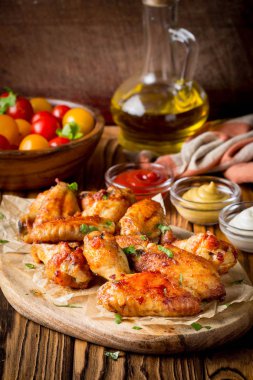 Ketçap ve hardal sosları ahşap oyun tahtası ile ızgara tavuk kanatları. Geleneksel pişmiş Barbekü buffalo