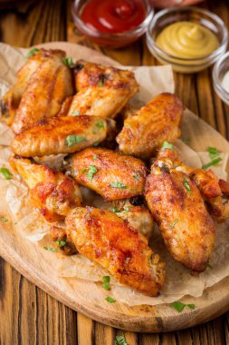 Ketçap ve hardal sosları ahşap oyun tahtası ile ızgara tavuk kanatları. Geleneksel pişmiş Barbekü buffalo