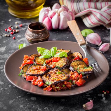 Kızarmış patlıcan dilimleri ile domates, otlar ve sarımsak, lezzetli vejetaryen yaz Aperatif. Izgara patlıcan