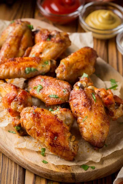 Ketçap ve hardal sosları ahşap oyun tahtası ile ızgara tavuk kanatları. Geleneksel pişmiş Barbekü buffalo