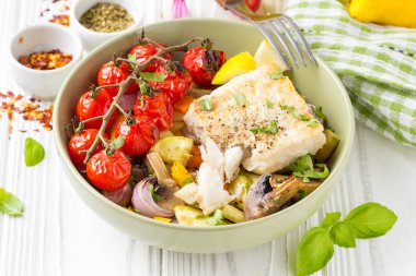 Mantar ve beyaz balık fileto bir kase pişmiş sebze. Kabak, domates bir şube, kırmızı soğan, biber ve sarımsak. Sağlıklı bir diyet yemek