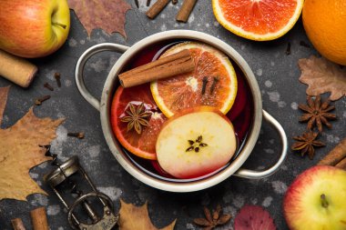 Portakal, elma, tarçın, küvet, tavada baharatlı sonbahar içki ile kırmızı mulled şarap hazırlanması. Üstten görünüm