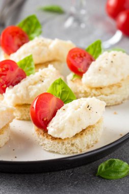 Kanepeler peynir mus, kiraz domates ve fesleğen ile gevrek ekmek peynir ve sarımsaklı köfte ile üzerine küçük bir sandviç. Lezzetli meze, şarap snack