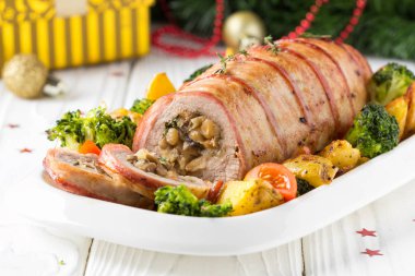 Pastırma sarılmış domuz eti rulo doldurulmuş mantar ve fasulye, sebze tarafında. Noel tatili için güzel Festival ana yemek