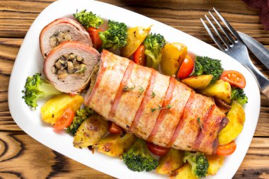 Pastırma sarılmış domuz eti rulo doldurulmuş mantar ve fasulye, sebze tarafında. Noel tatili için güzel Festival ana yemek