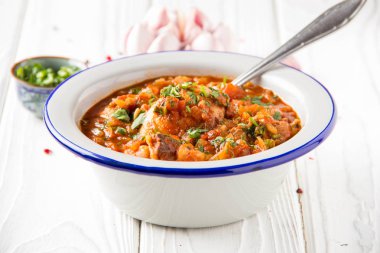 Otlar ve soğan, kişniş maydanoz nane, geleneksel oryantal tabak chakhokhbili, lezzetli ev yapımı yemekler ile domates soslu tavuk. Açık renkli